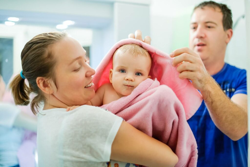 Famille avec bébé enveloppé dans une serviette
